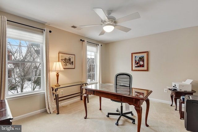 carpeted home office featuring ceiling fan