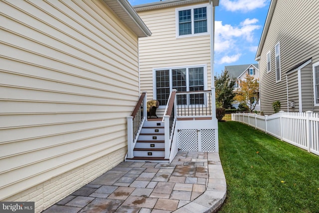 entrance to property with a patio and a lawn