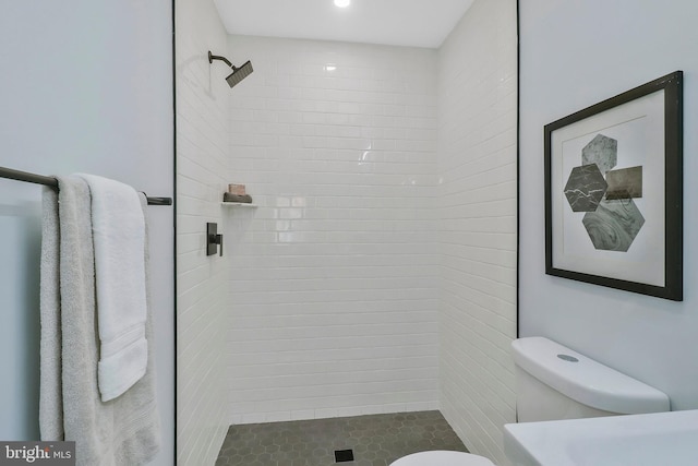 bathroom featuring toilet and tiled shower