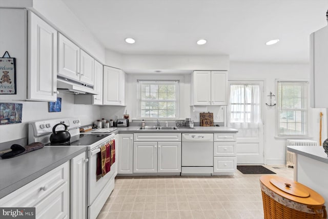 kitchen with white cabinets, white appliances, radiator heating unit, and sink