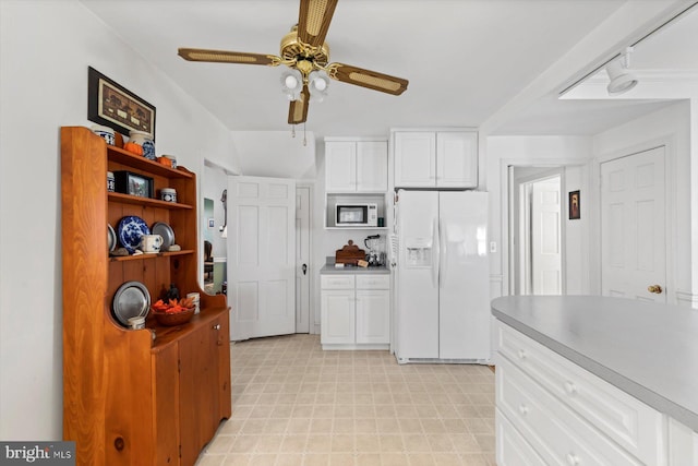 kitchen with white cabinets, ceiling fan, and white appliances