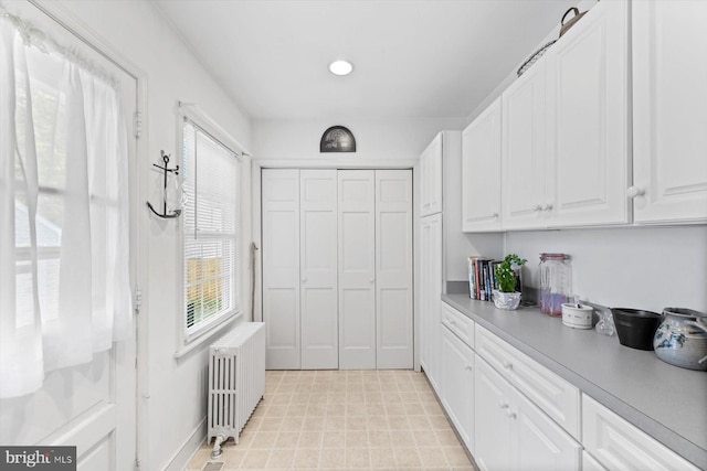 kitchen with white cabinetry and radiator heating unit