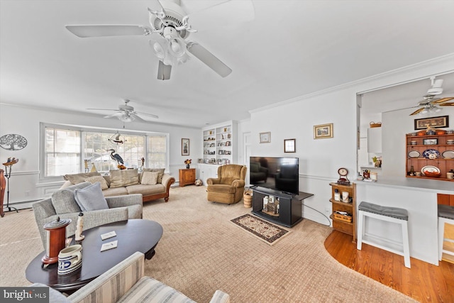 living room featuring ceiling fan, a baseboard radiator, light hardwood / wood-style flooring, and crown molding