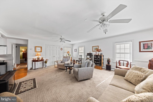 living room featuring ornamental molding, light colored carpet, and ceiling fan