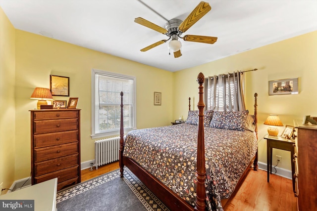 bedroom featuring light wood-type flooring, ceiling fan, and radiator