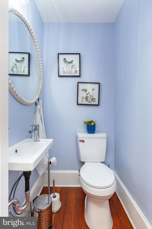 bathroom featuring toilet and wood-type flooring