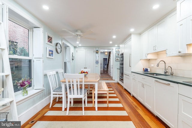 kitchen featuring white cabinets, sink, and light hardwood / wood-style flooring