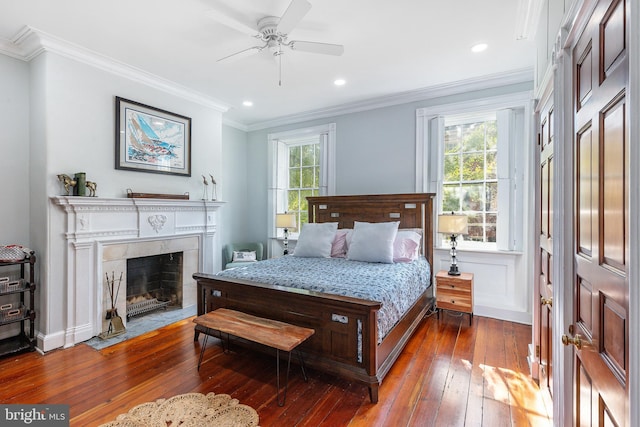 bedroom with ceiling fan, multiple windows, and dark hardwood / wood-style flooring