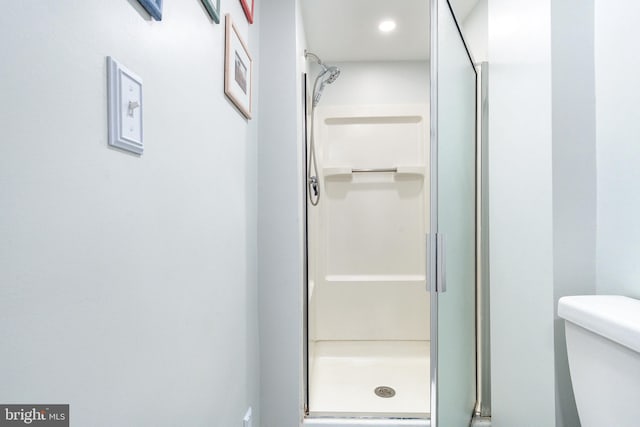 bathroom with an enclosed shower and toilet