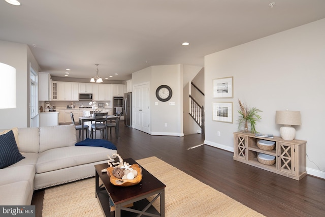 living room with an inviting chandelier and dark hardwood / wood-style flooring