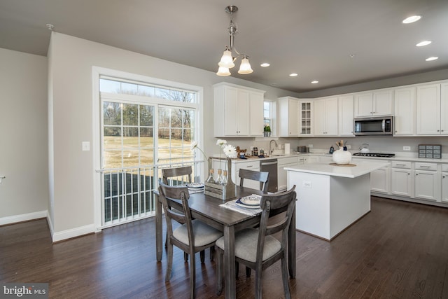 dining area featuring sink, dark hardwood / wood-style flooring, and an inviting chandelier