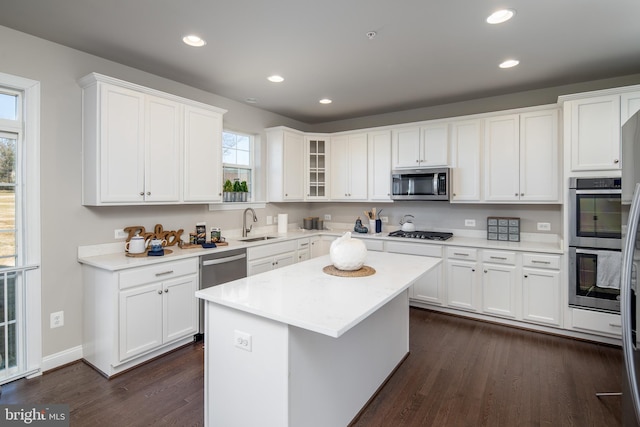 kitchen featuring stainless steel appliances, a center island, dark hardwood / wood-style flooring, and white cabinets