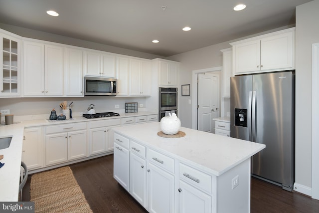 kitchen featuring appliances with stainless steel finishes, a kitchen island, dark hardwood / wood-style floors, and white cabinets