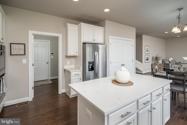 kitchen with dark hardwood / wood-style floors, hanging light fixtures, a center island, white cabinetry, and appliances with stainless steel finishes