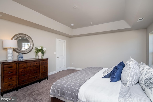 carpeted bedroom with a raised ceiling