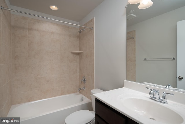 full bathroom featuring toilet, tiled shower / bath, and vanity