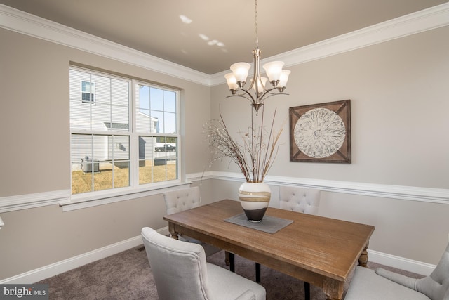 carpeted dining area with ornamental molding and a chandelier