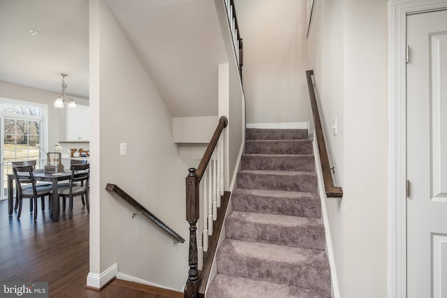 stairway featuring a chandelier and wood-type flooring