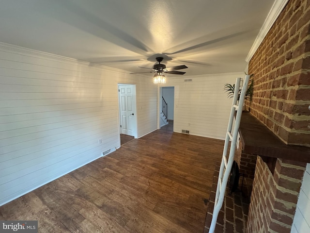 unfurnished living room featuring ceiling fan, crown molding, and dark hardwood / wood-style flooring