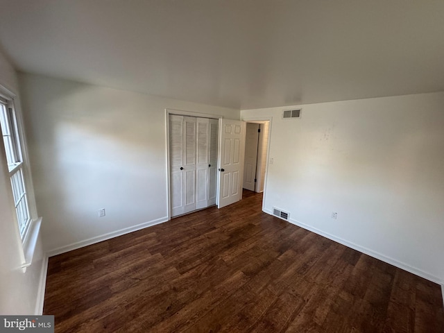 unfurnished room with dark wood-type flooring and plenty of natural light