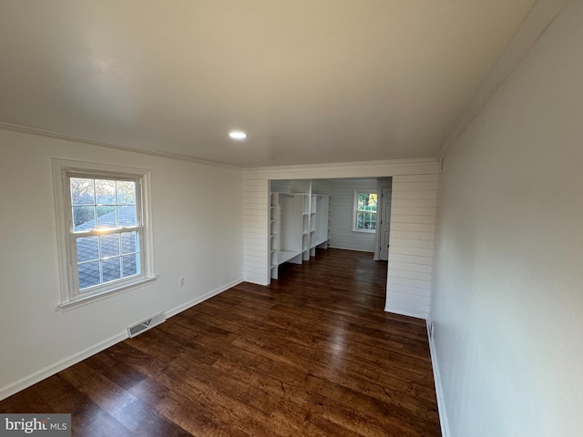 empty room with ornamental molding and dark hardwood / wood-style floors