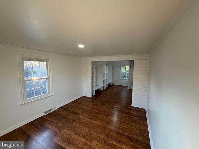 empty room with visible vents, recessed lighting, dark wood finished floors, crown molding, and baseboards
