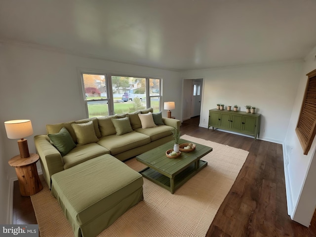 living room with dark wood-style flooring, baseboards, and ornamental molding
