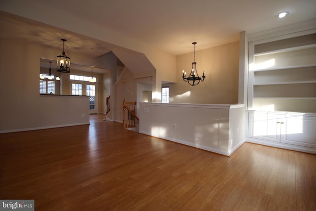 empty room with a chandelier and wood-type flooring