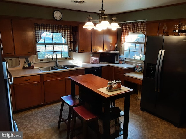 kitchen featuring sink, crown molding, black appliances, and decorative light fixtures