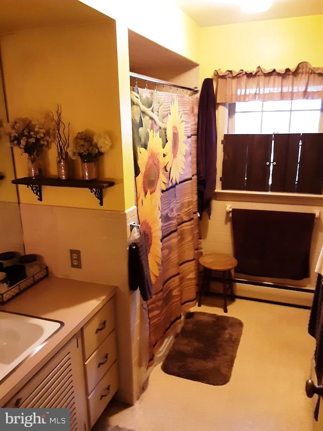 bathroom featuring vanity, curtained shower, and baseboard heating