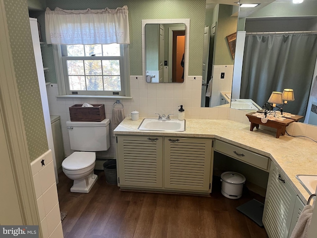 bathroom featuring vanity, toilet, hardwood / wood-style flooring, and tile walls