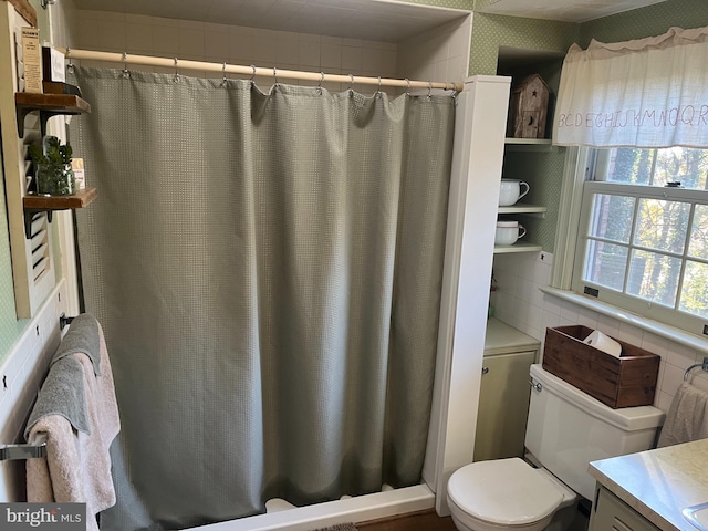 bathroom featuring vanity, toilet, decorative backsplash, and walk in shower