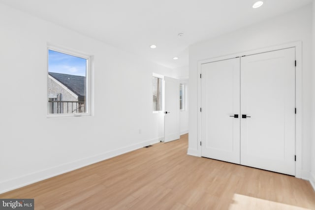 unfurnished bedroom featuring a closet and light wood-type flooring