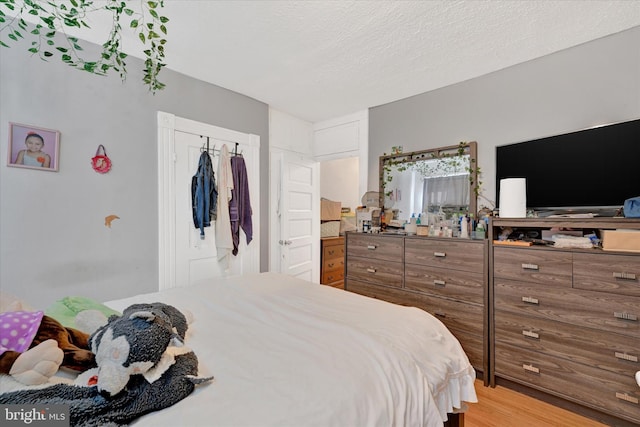 bedroom featuring a textured ceiling and light wood-type flooring