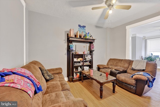 living room with hardwood / wood-style floors, a textured ceiling, and ceiling fan