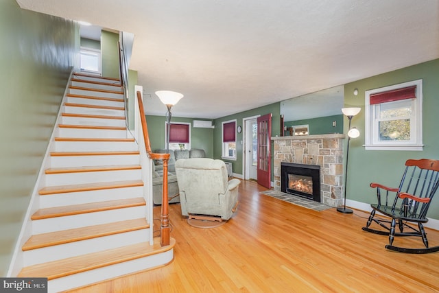 living room featuring hardwood / wood-style flooring and a stone fireplace