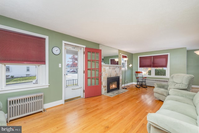 living room featuring a fireplace, hardwood / wood-style flooring, and radiator