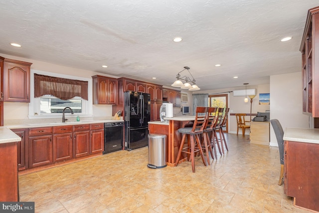 kitchen with sink, black appliances, a kitchen breakfast bar, hanging light fixtures, and a kitchen island