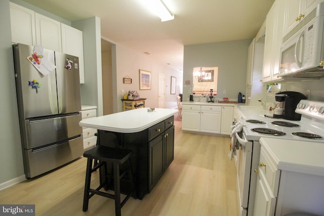 kitchen featuring a kitchen island, a kitchen breakfast bar, white cabinetry, light wood-type flooring, and white appliances