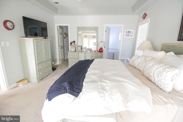 bedroom featuring light carpet and ensuite bath