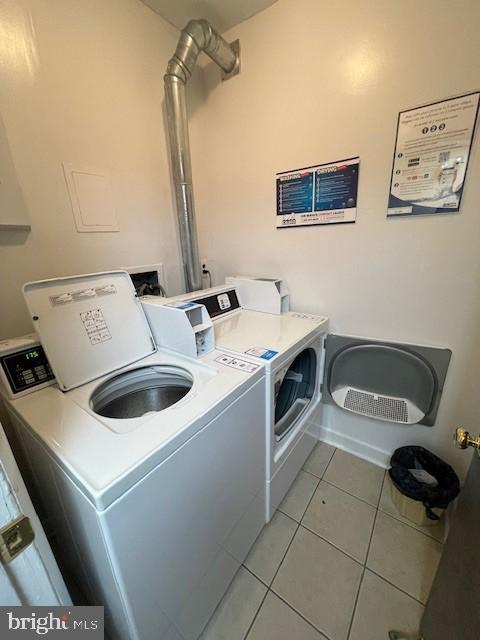 washroom with light tile patterned floors and washing machine and clothes dryer