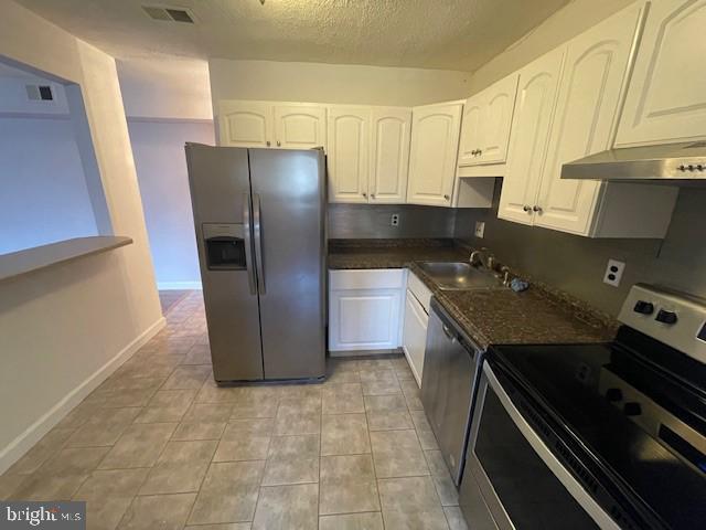 kitchen with appliances with stainless steel finishes, sink, and white cabinets