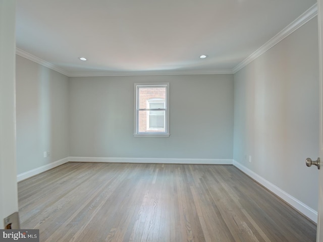 empty room featuring light wood-type flooring and ornamental molding