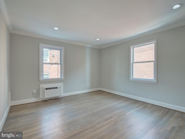 empty room with crown molding, light hardwood / wood-style floors, and an AC wall unit