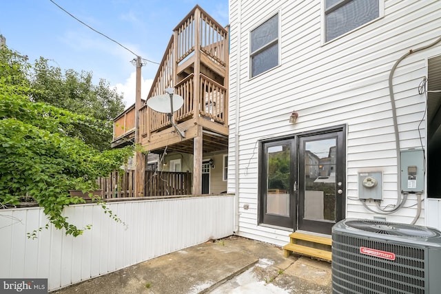 doorway to property with cooling unit, a balcony, and french doors