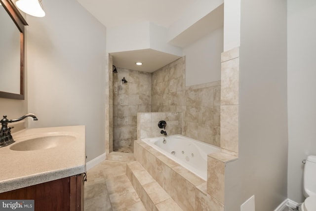bathroom featuring a stall shower, baseboards, toilet, a jetted tub, and vanity