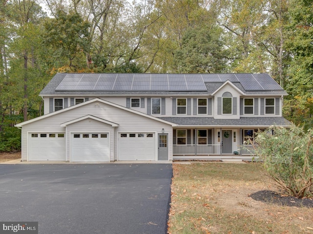 view of front of house with covered porch and solar panels