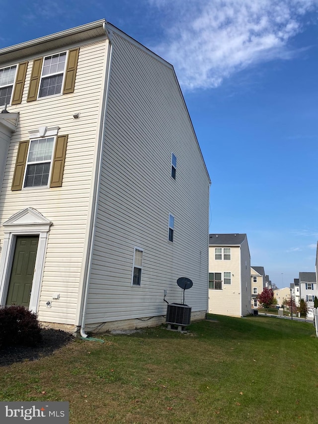 view of home's exterior with central air condition unit and a yard