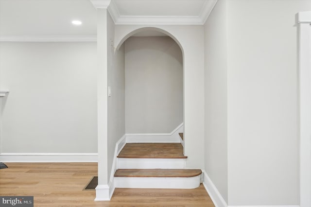 staircase featuring hardwood / wood-style floors and ornamental molding