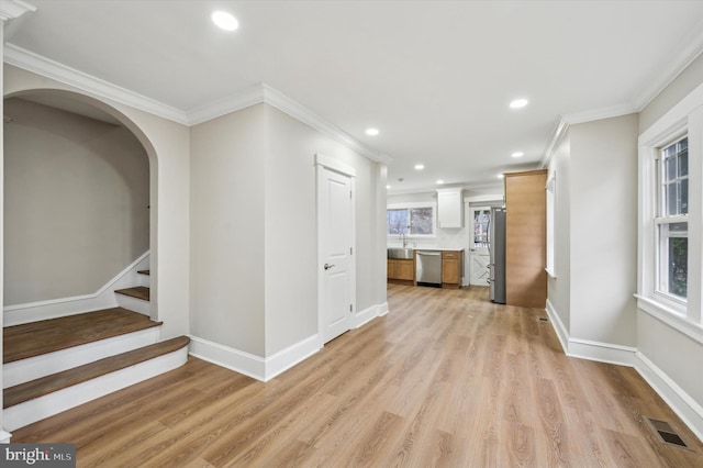 interior space featuring sink, light wood-type flooring, and ornamental molding